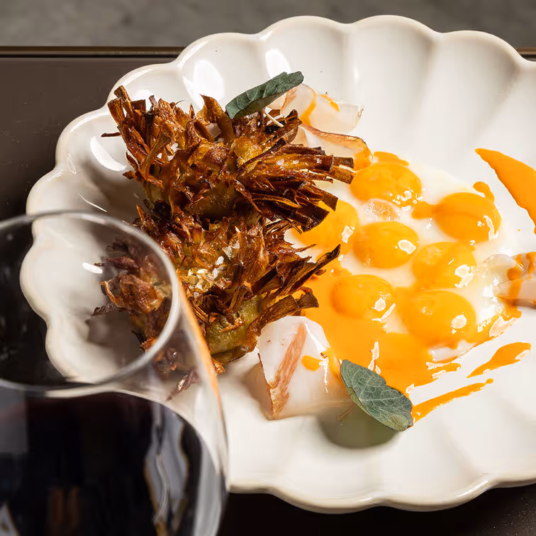 Gourmet dish with crisp vegetables and yellow sauce, garnished with green leaves