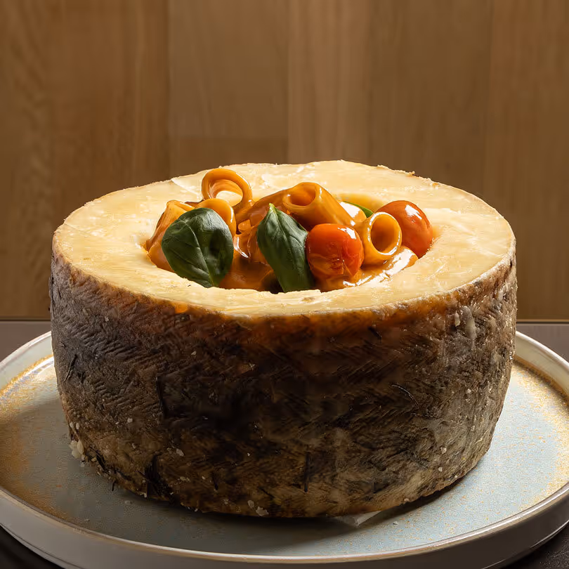 Round cheese topped with cherry tomatoes and green leaves